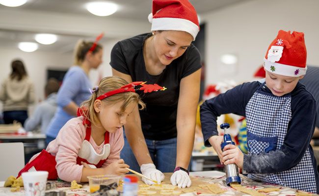 Mutter und Kinder backen Plätzchen in der Jugendherberge beim Adventsprogramm