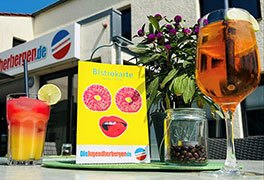 Bistrotisch mit einen Cocktail und einer Weinschorle