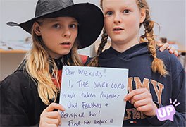 Zwei M�dchen sind beim Feriencamp als Zauberer verkleiden und halten einen Zelten hoch.
