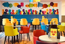 Modernes Bistro mit bunten Sthlen und bunter Wanddekoration