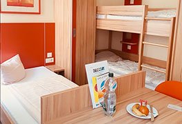Mehrbettzimmer der Jugendherberge Bad Bergzabern mit Obstteller auf dem Tisch