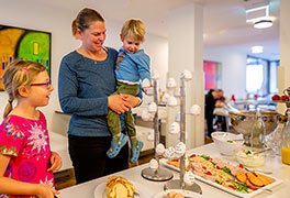 Mutter mit Kindern am Frühstücksbüfett der Jugendherberge Bad Bergzabern