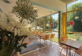 Helles Restaurant der Jugendherberge Dreisbach mit Blumen und sommerlicher Dekoration