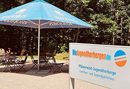 Außenbistro der Pfälzerwald-Jugendherberge Hochspeyer mit Schild