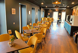 Stilvolles Bistro der Jugendherberge Idar-Oberstein mit gelben Polstersesseln, dunklen Tischen und moderner Beleuchtung in einer einladenden Atmosphäre.