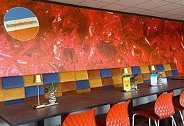 Modernes Restaurant der Jugendherberge Idar-Oberstein mit orangefarbenen Stühlen und Sitzbank.