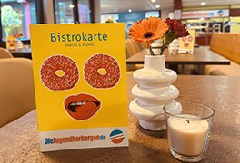 Die gelbe Bistrokarte auf dem Tisch im Bistro Jugendherberge Oberwesel.