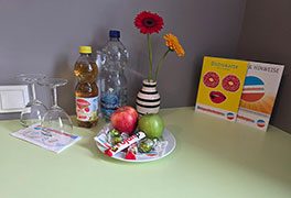 Begrüßungsteller mit Obst, Süßigkeiten und Getränken auf Tisch im Zimmer Jugendherberge Traben-Trarbach