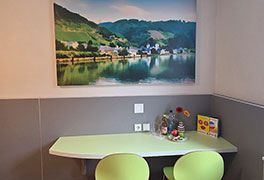 Grüner Tisch im Zimmer Jugendherberge Traben-Trarbach. Oberndrüber hängt ein Landschaftsbild