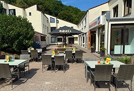 Außenbistro der Jugendherberge mit aufgespannten Sonnenschirmen