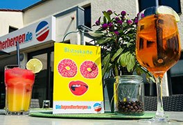 Bistrotisch mit Cocktail und Weinschorle