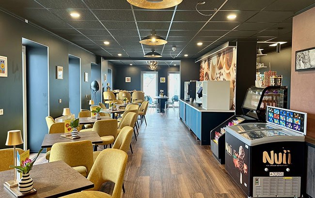 Stilvolles Bistro der Jugendherberge Idar-Oberstein mit gelben Polstersesseln, dunklen Tischen und moderner Beleuchtung in einer einladenden Atmosphäre.