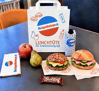 Lunchtüte der Jugendherbergen mit Brötchen, Obst, Wasser und Snacks