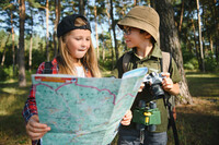Schüler mit Karte im Wald 